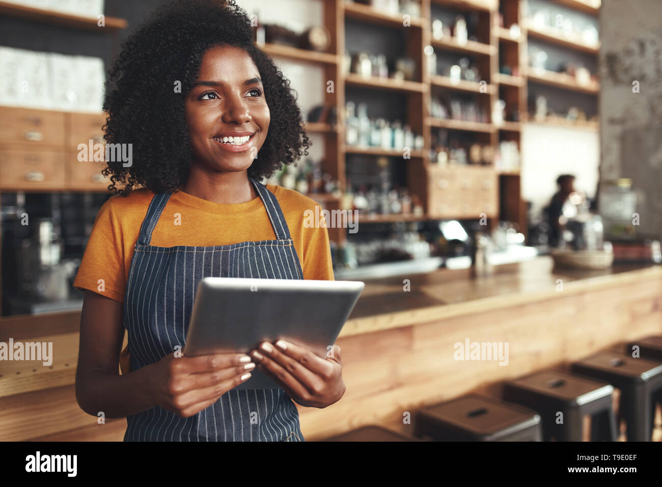 Jeune femme propriétaire holding digital tablet dans son café à aw Banque D'Images