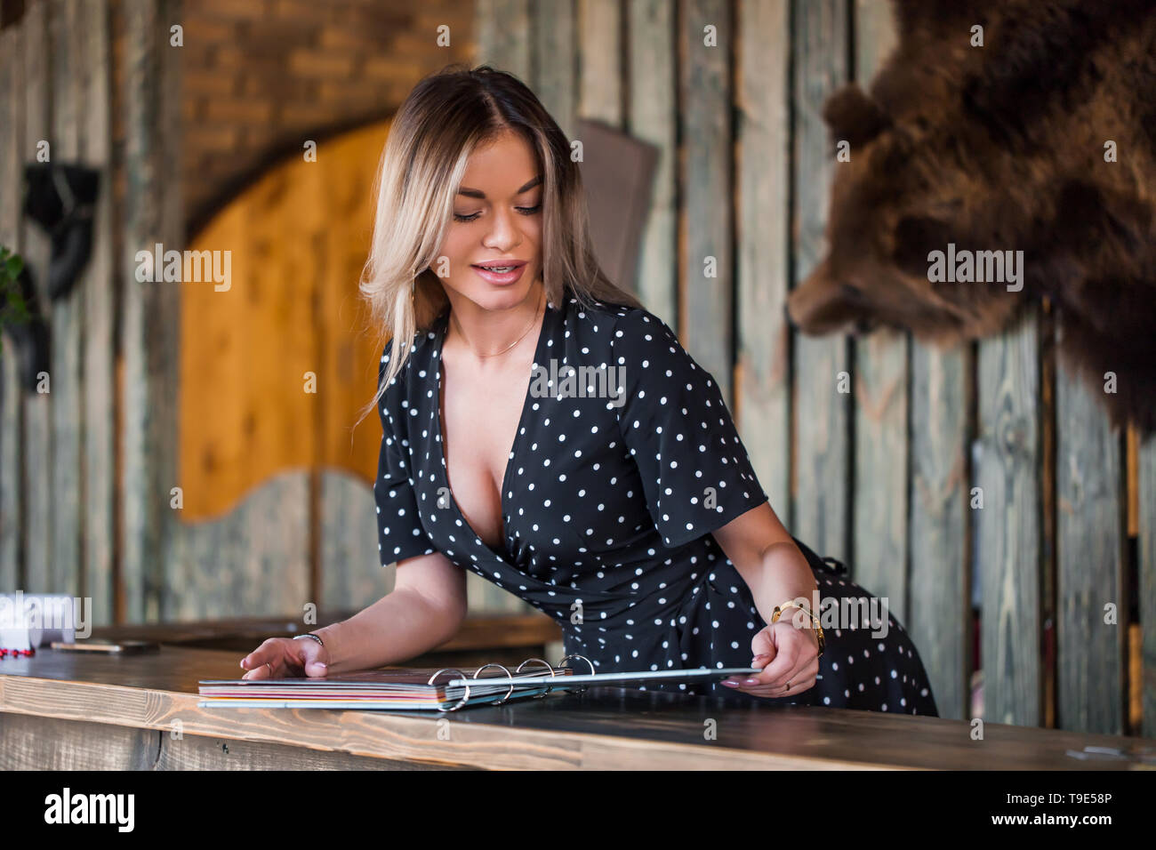 Belle jeune femme à l'accueil affiche le menu Service. Studio de beauté, Banque D'Images