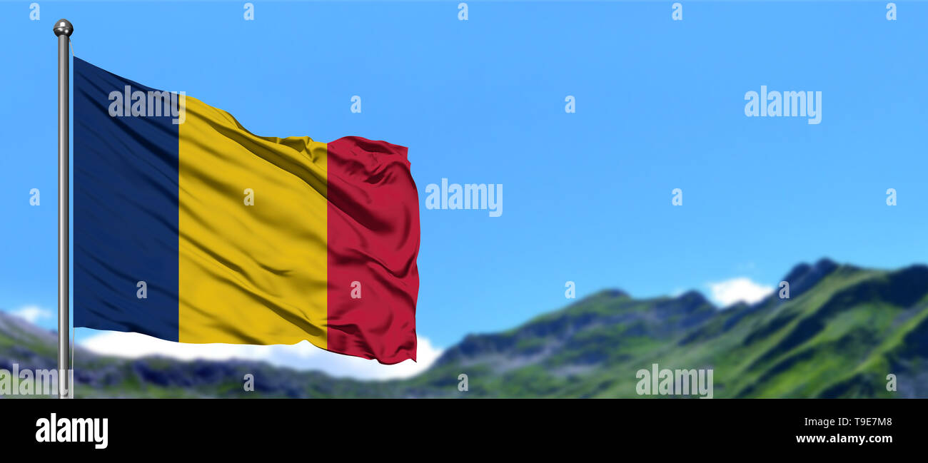 De brandir le drapeau du Tchad dans le ciel bleu avec des champs verts au sommet de montagne l'arrière-plan. Thème de la nature. Banque D'Images