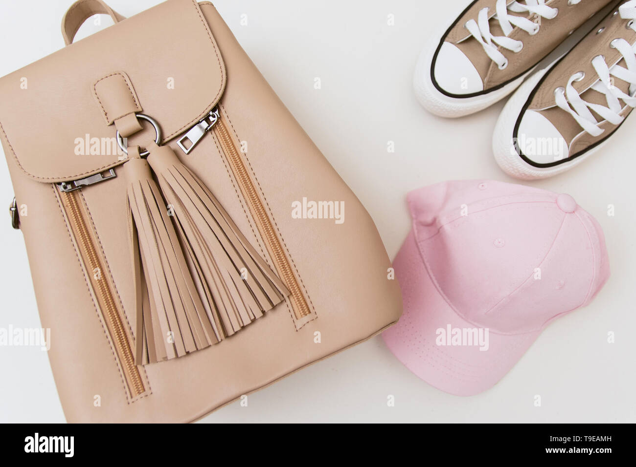 Espadrilles beige, sac à dos et une coiffe rose pastel sur fond clair. Place pour texte, copyspace, télévision lay Banque D'Images