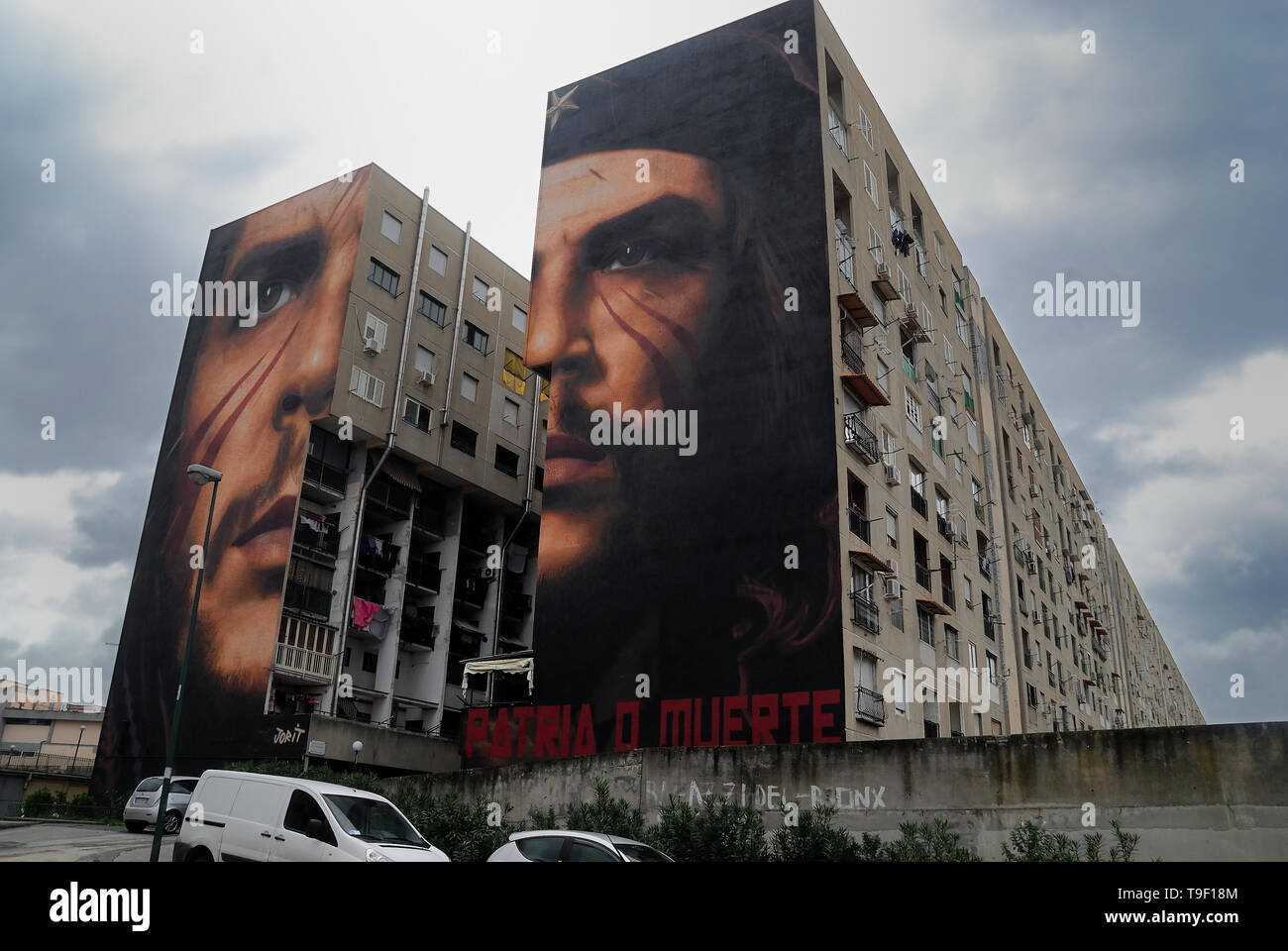 Agoch Jorit, 28, rue napolitaine est artiste de renommée internationale, père et mère néerlandaise. Il crée des peintures murales géantes sur les façades des immeubles de banlieue à travers le monde. Ses œuvres sont présentes à Buenos Aires, Córdoba, Aruba, Santiago du Chili, New York, Miami, Las Vegas, Los Angeles, San Francisco, Shenzhen, Gaza. En Italie Jorit est principalement actif à Naples où il fait d'immenses peintures sur façades aveugles des immeubles de banlieue et aussi dans le centre historique. Banlieue de Naples, San Giovanni a Teduccio trimestre, bâtiments populaires dans Taverna del Ferro. La peinture de Ernesto Che Gueva Banque D'Images