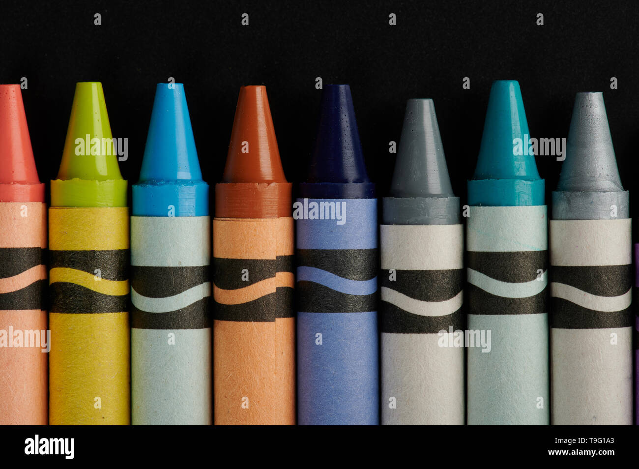 Ligne de crayons colorés sur fond noir board Banque D'Images