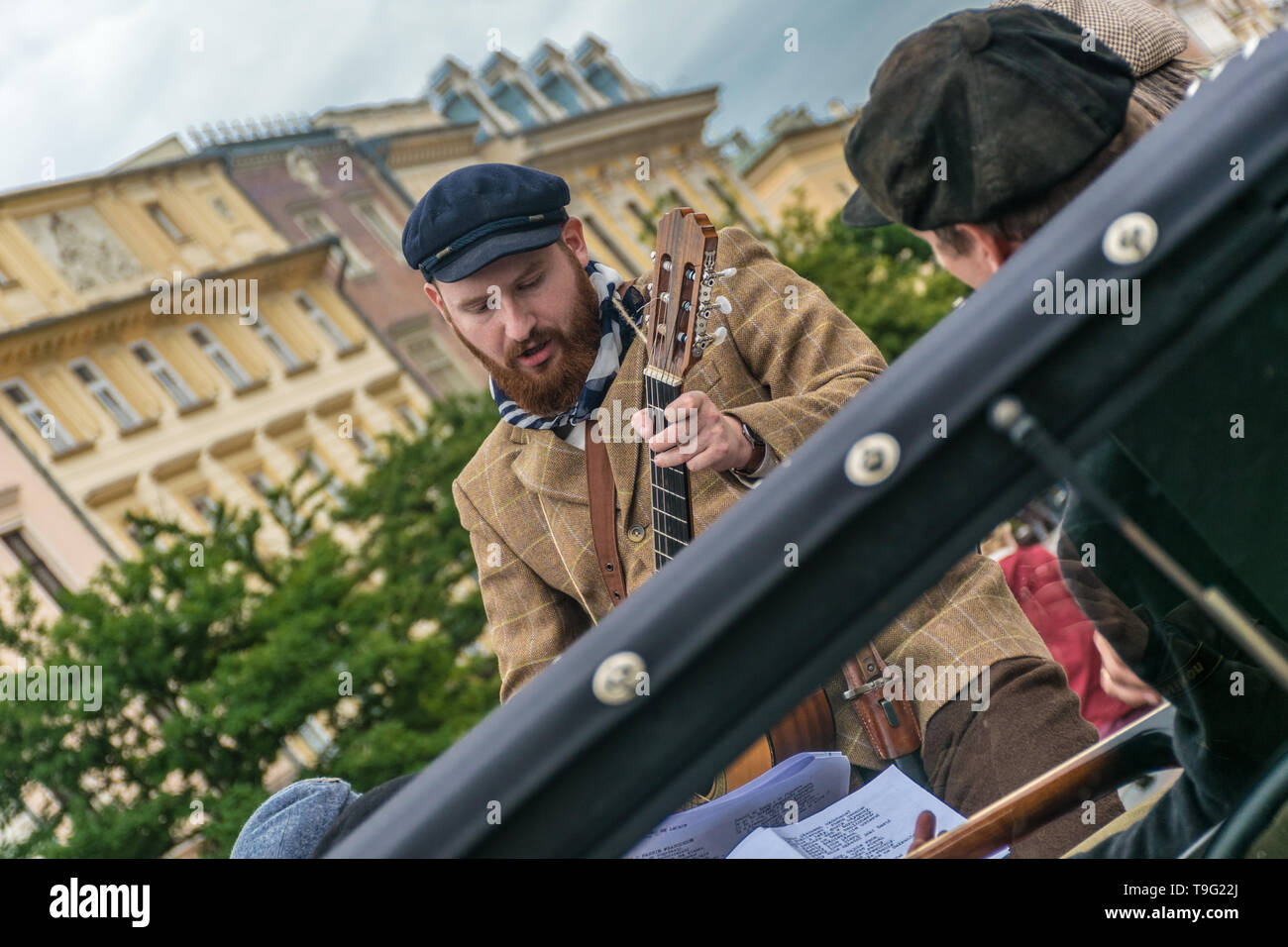 Cracovie, Pologne - 23 septembre 2018 : Musicien habillé en paysan chantant et jouant de la guitare avec une bande sur le dessus d'une antique camionnette à la main Banque D'Images