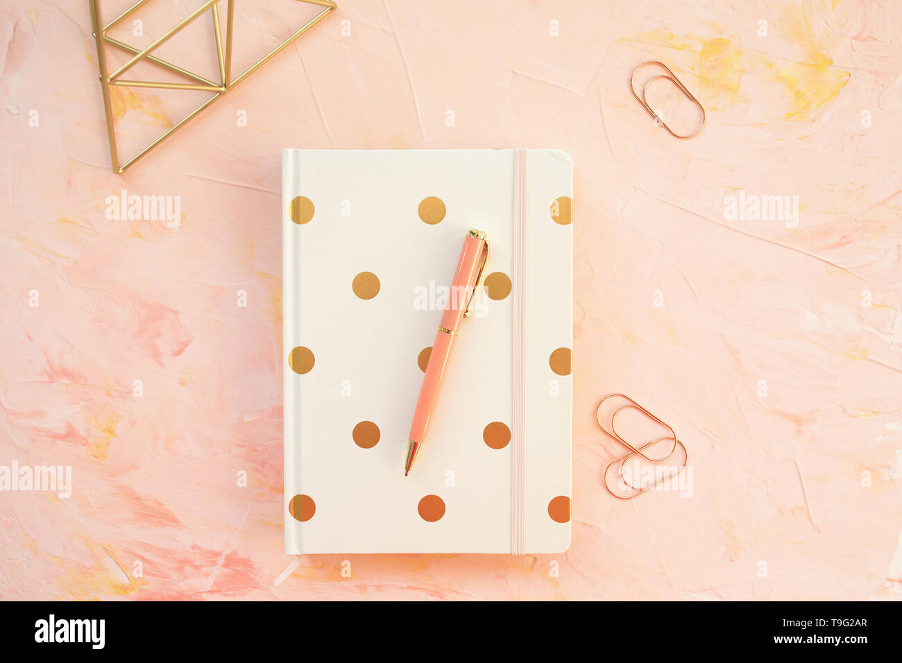 Le bloc-notes et stylo sur un espace de bureau, fond rose. Mise à plat, vue du dessus, les médias sociaux hero modèle d'en-tête, style de concept. Banque D'Images