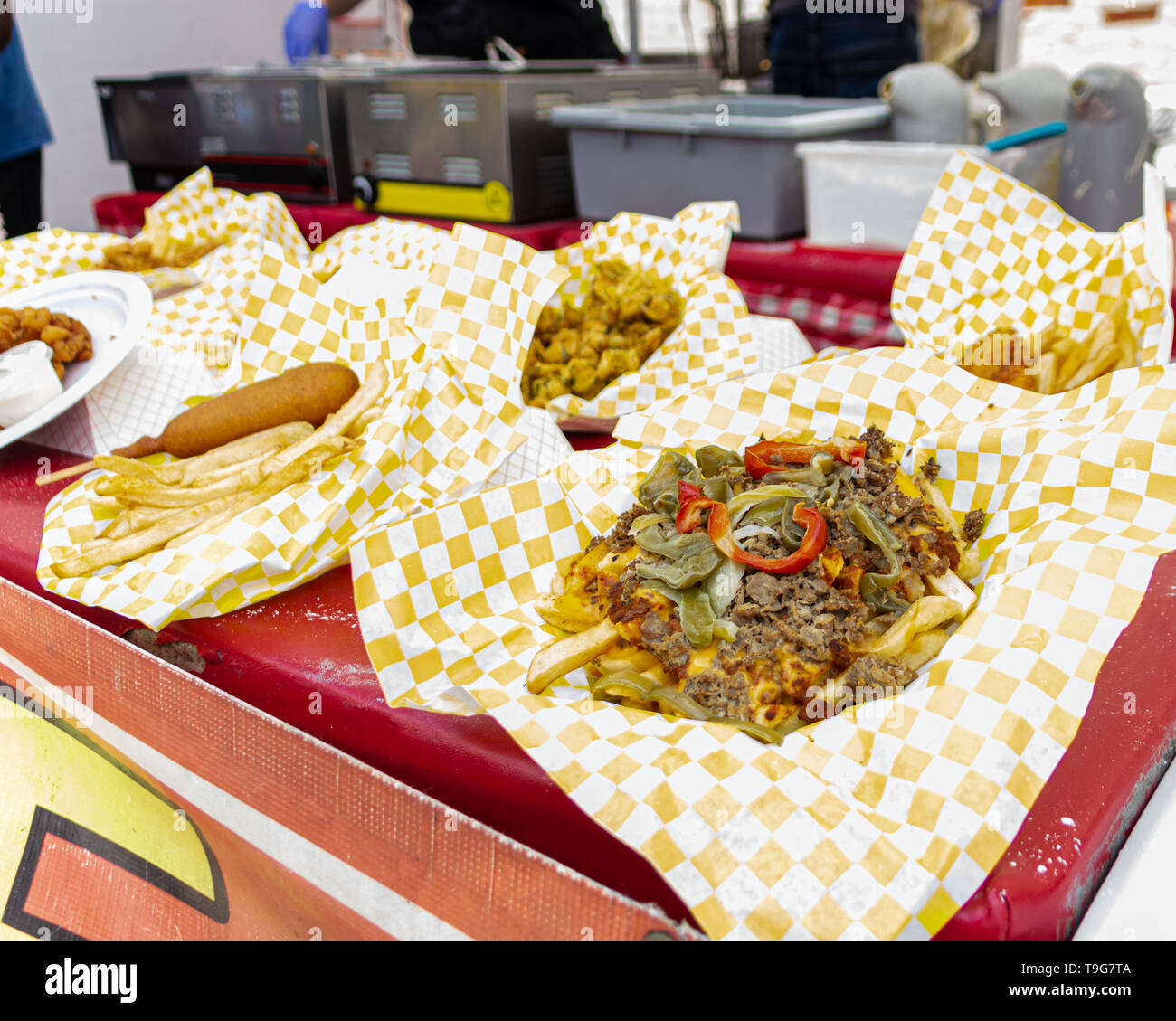 Délicieux menu, comme corndogs, fromage steak-frites et poulet, sont affichées par un stand de nourriture par les vendeurs de rue. Banque D'Images