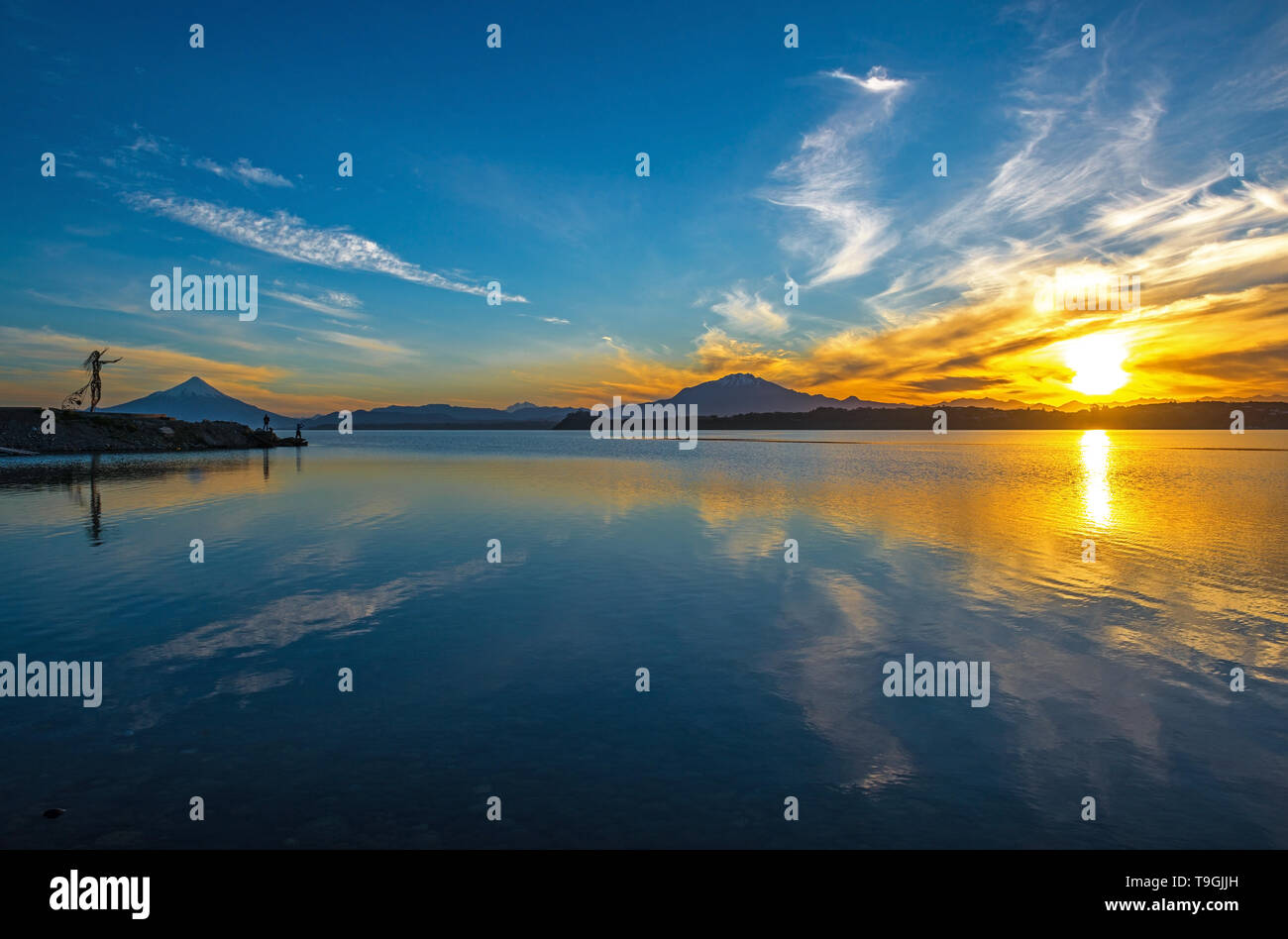 Lever du soleil à Puerto Varas avec une vue sur le volcan Osorno et Calbuco ainsi que les pêcheurs locaux des silhouettes, lac Llanquihue, au Chili. Banque D'Images