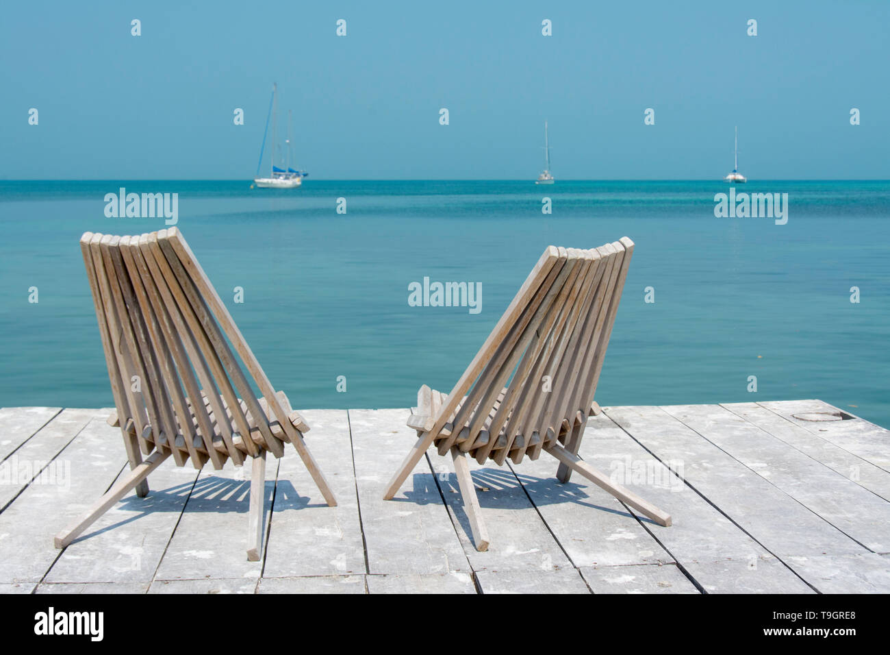 Chaises longues sur dock, Caye Caulker, Belize Banque D'Images