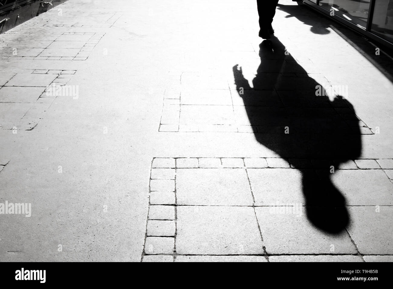 Ombre floue silhouette d'une personne qui marche sur le trottoir de la ville Banque D'Images