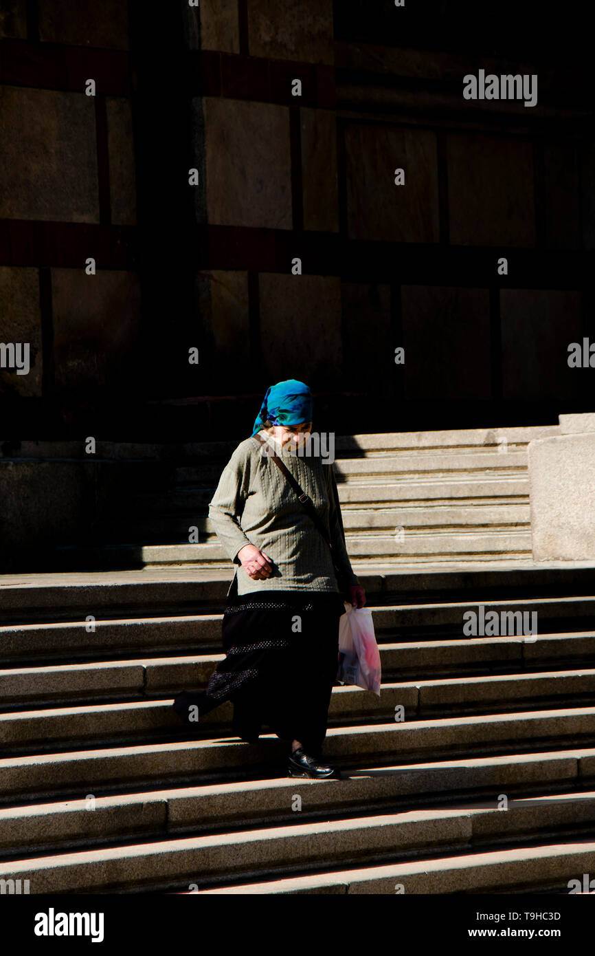 Belgrade, Serbie - Avril 22, 2019 : Senior woman wearing scarf bleu descendant les escaliers de l'église orthodoxe de Saint Marc Banque D'Images