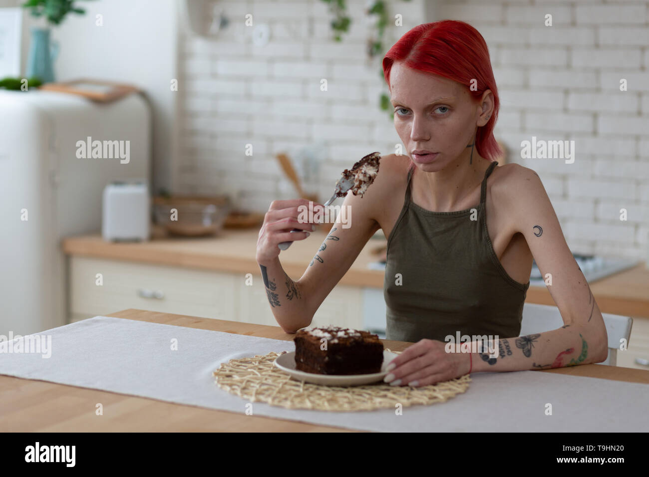 Femme avec la boulimie holding fourche avec gros morceau de gâteau Banque D'Images