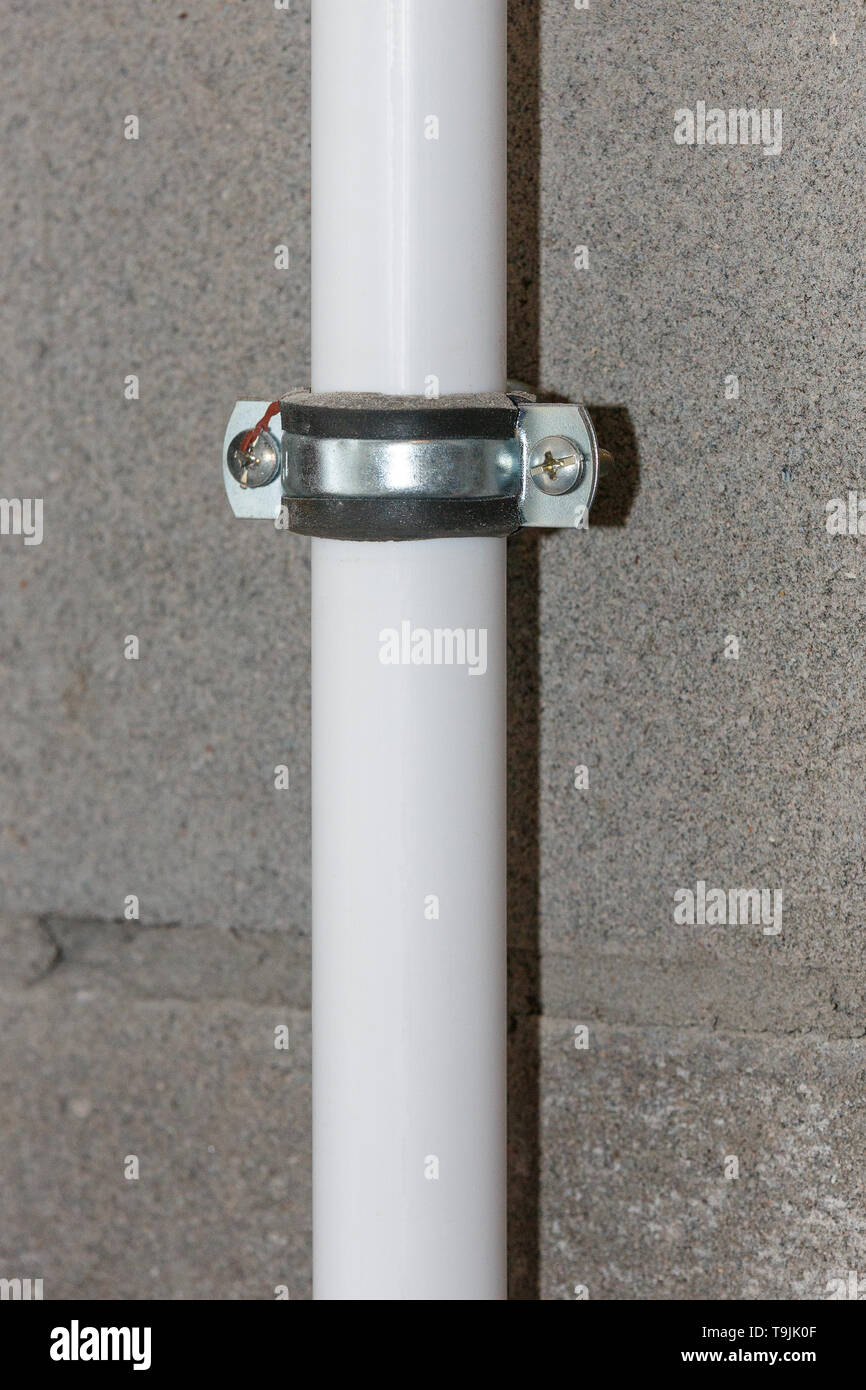 Fixer le tuyau blanc pour le mur de béton de près Photo Stock - Alamy