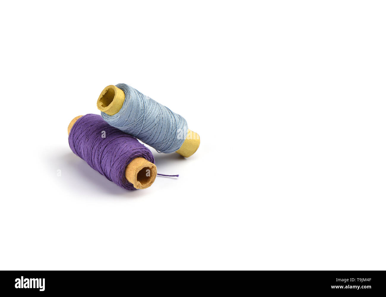 Violet et bleu clair coton fils sur le manchon en carton pour la machine à coudre. Concept de couture. Copy space Banque D'Images