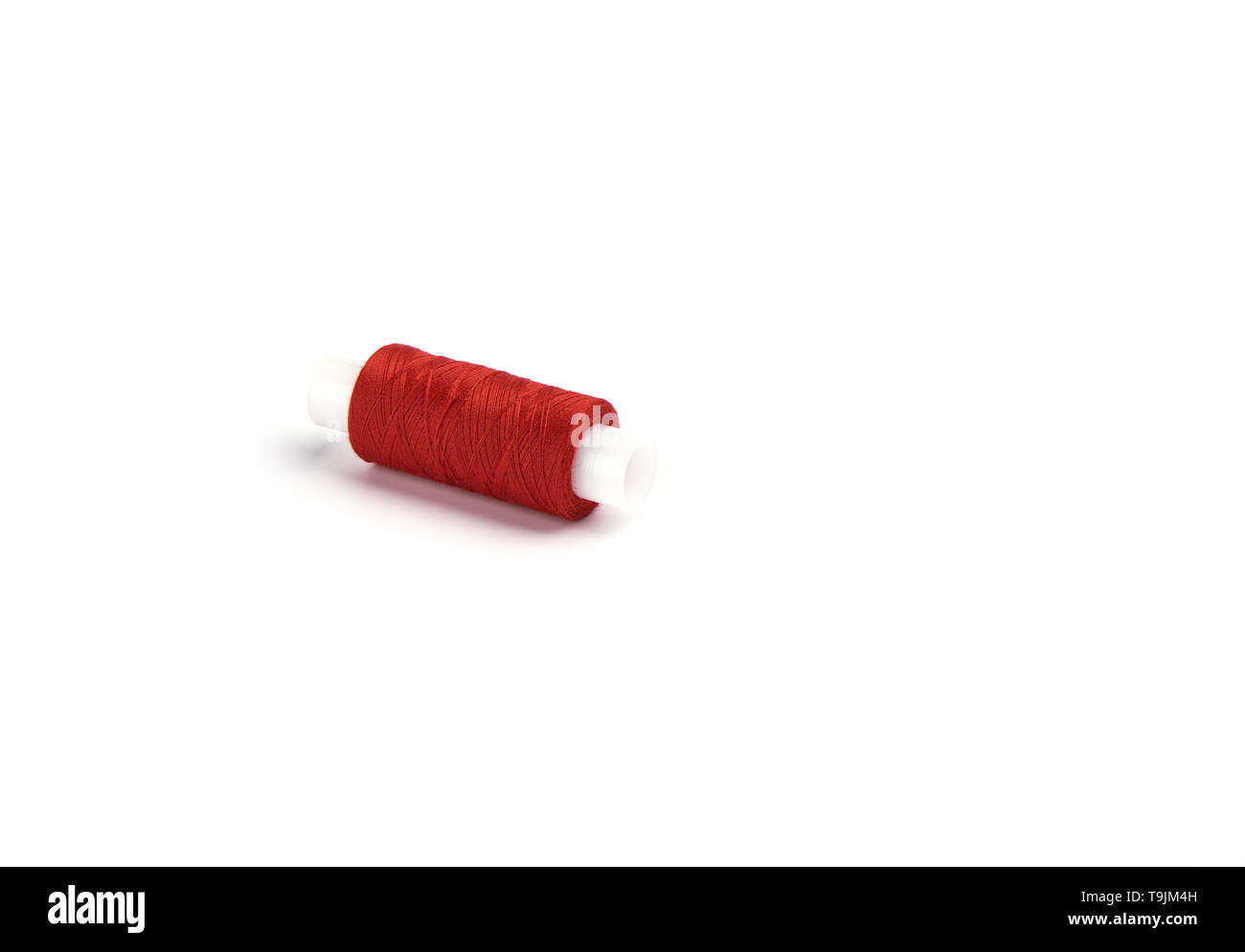 Le coton fils rouges sur le manchon en plastique pour la machine à coudre. Concept de couture. Copy space Banque D'Images