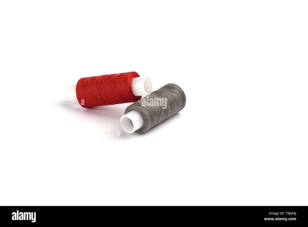 Rouge et gris coton fils sur le manchon en plastique pour la machine à coudre. Concept de couture. Copy space Banque D'Images