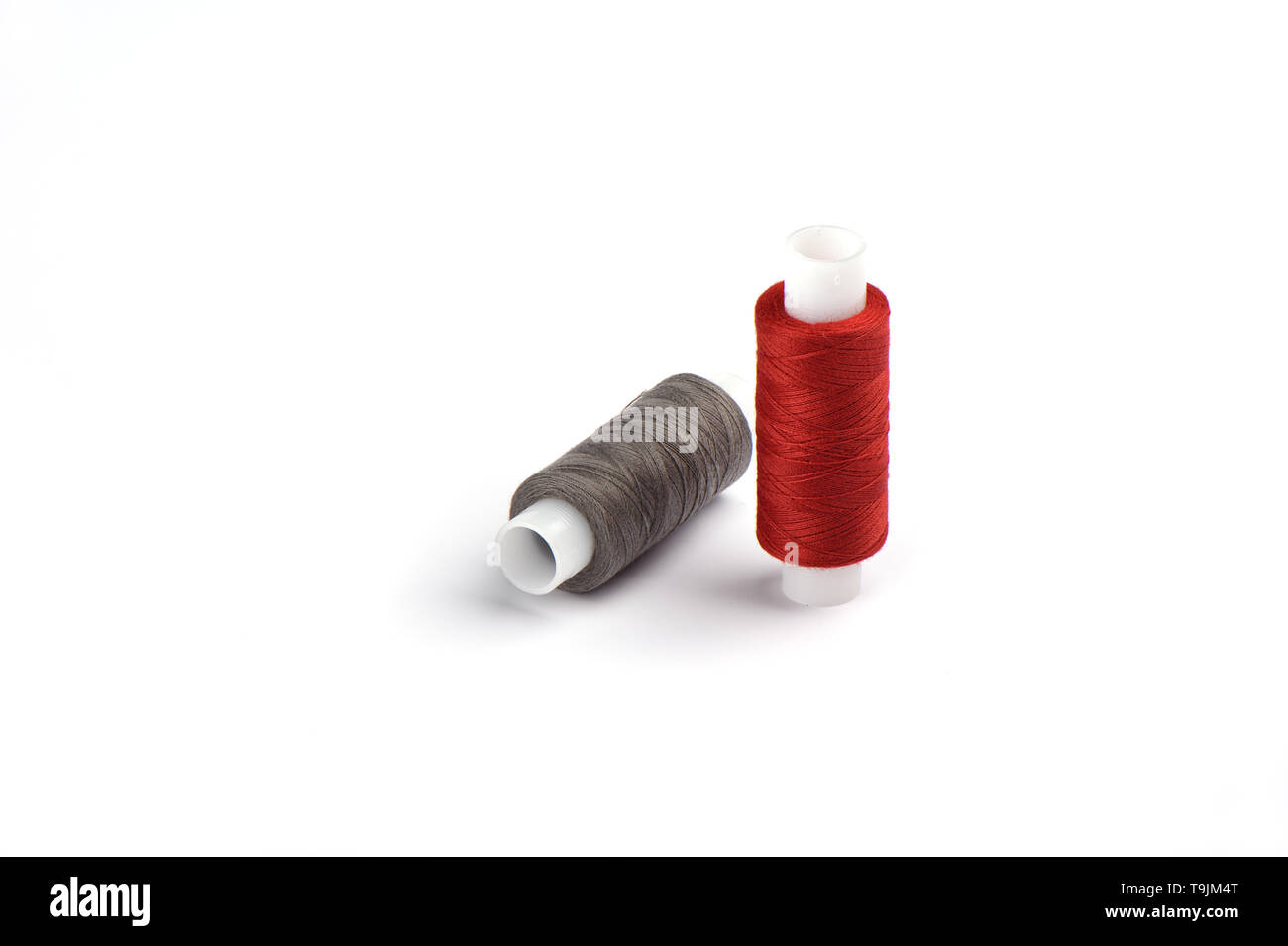 Rouge et gris coton fils sur le manchon en plastique pour la machine à coudre. Concept de couture. Copy space Banque D'Images