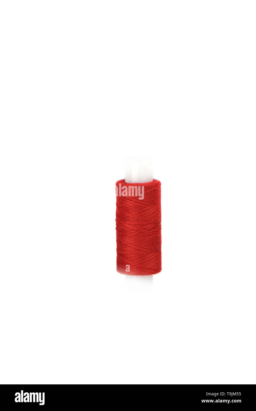 Le coton fils rouges sur le manchon en plastique pour la machine à coudre. Banque D'Images