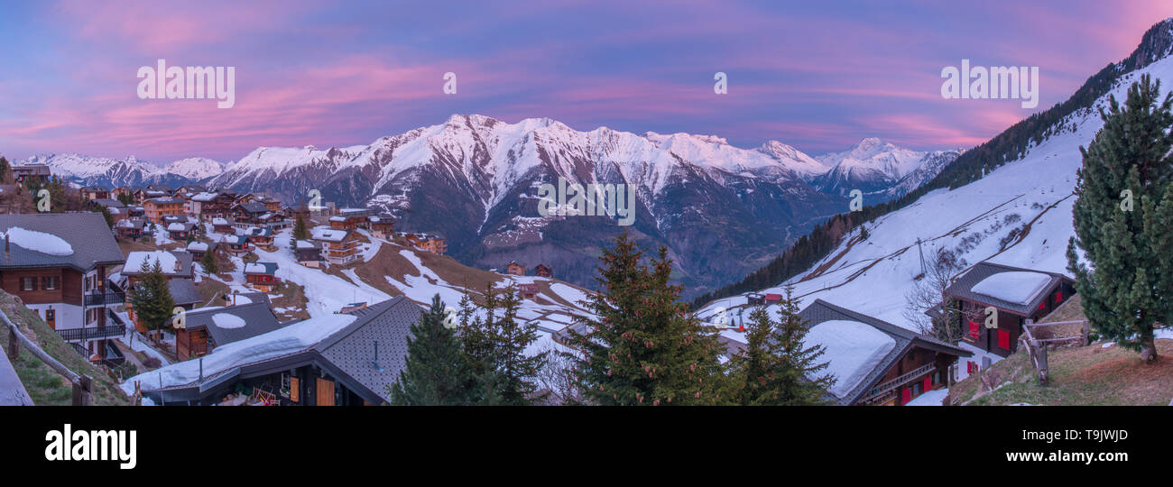 Ciel peint, ciel coloré au coucher du soleil. Vue panoramique de snowcapped mountain range, les Alpes suisses, à partir d'une ville de haute montagne en Suisse. Banque D'Images