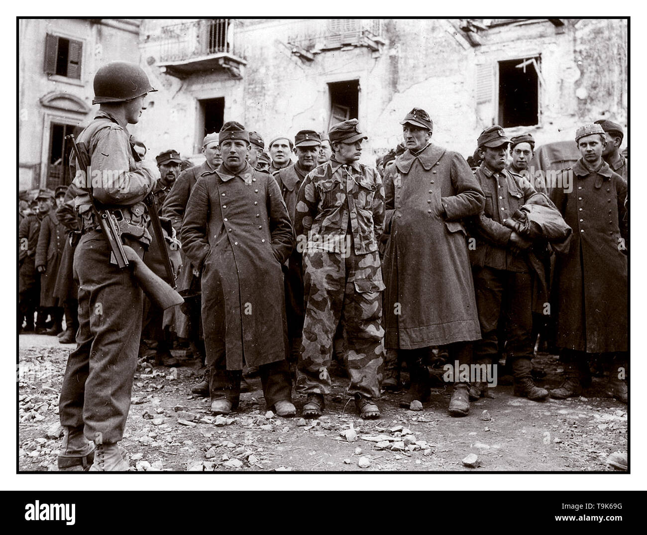 WW2 Archive armée allemande de la Seconde Guerre mondiale prisonniers groupe disparate de la Wehrmacht en uniforme de l'armée allemande détenus gardés par un jeune soldat GI américain à Anzio Italie 1944 Banque D'Images