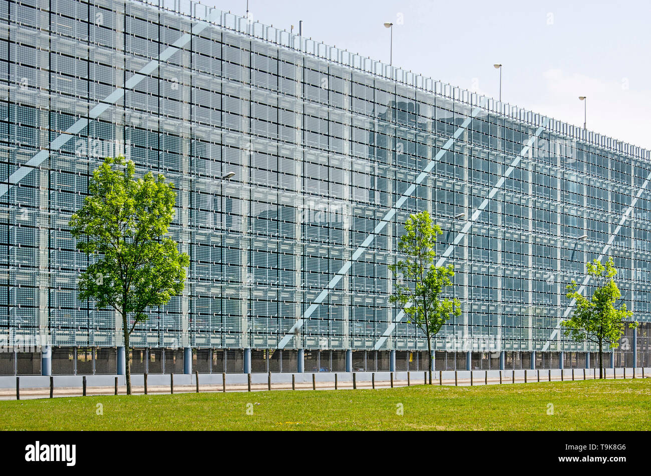 Leiden, Pays-Bas, le 18 mai 2019 : pelouse et trois jeunes arbres en avant de la façade en verre d'un parking couvert à l'bio science park Banque D'Images
