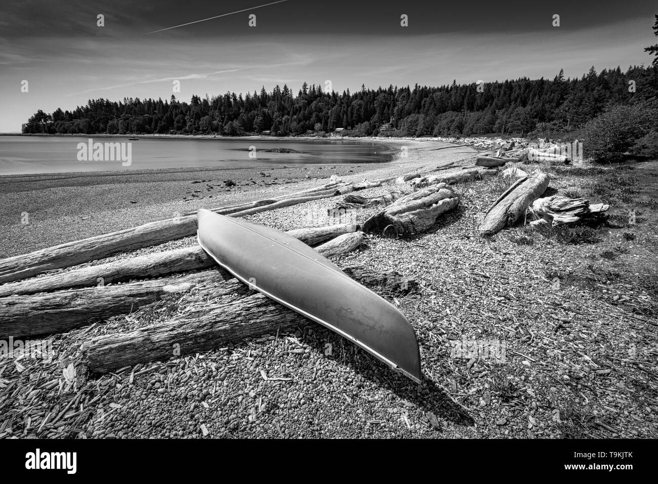 Plage rocheuse de soleil le long de la côte Pacifique du nord-ouest de l'île de Bowen à Howe Sound avec de spectaculaires vues sur le phare de l'ensemble juste au large de la côte de Vancouver BC Banque D'Images