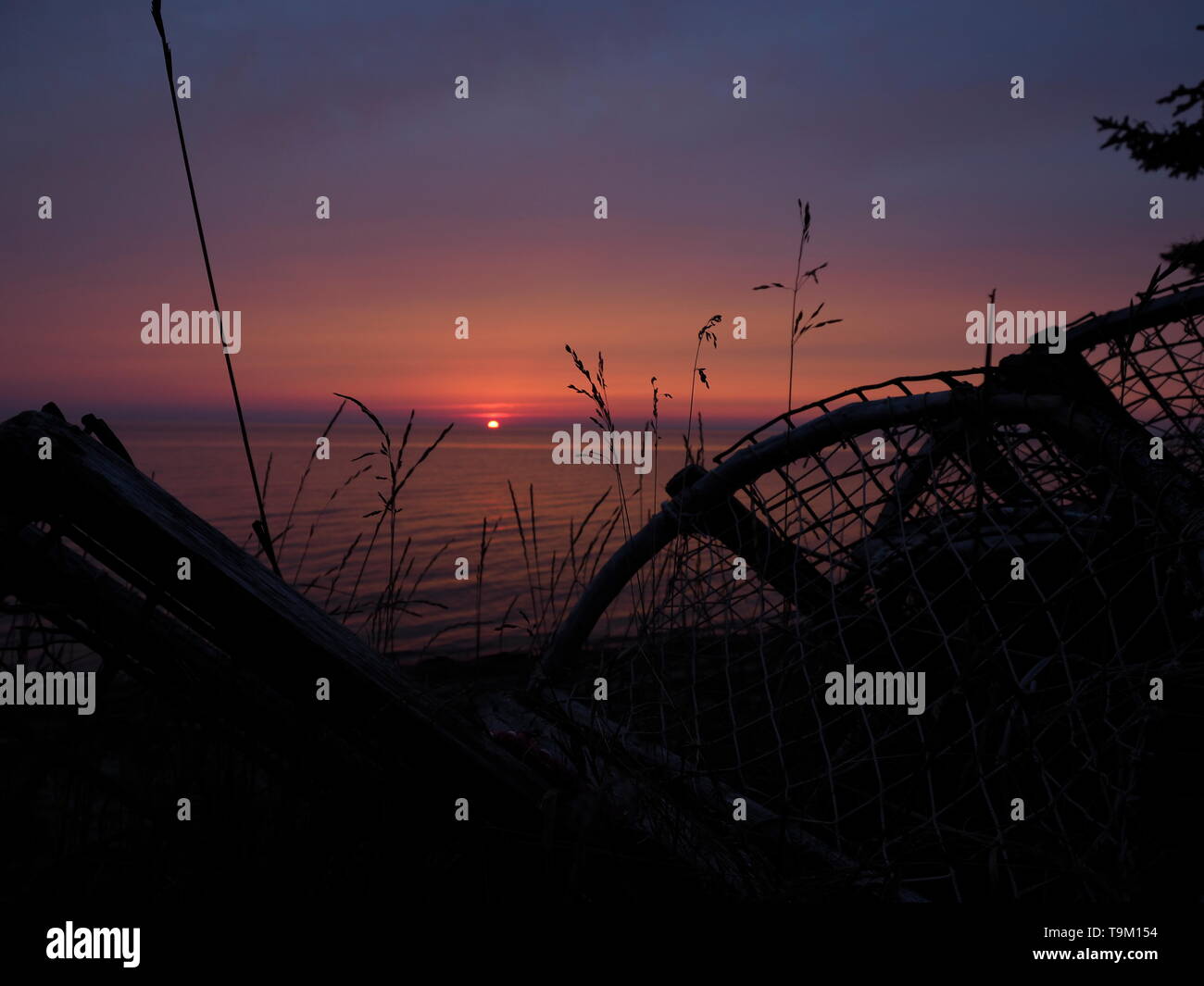 Magnifique coucher de soleil avec des casiers à homard en silhouette d'une plage camping sur l'Île Miscou, Nouveau Brunswick, Canada Banque D'Images