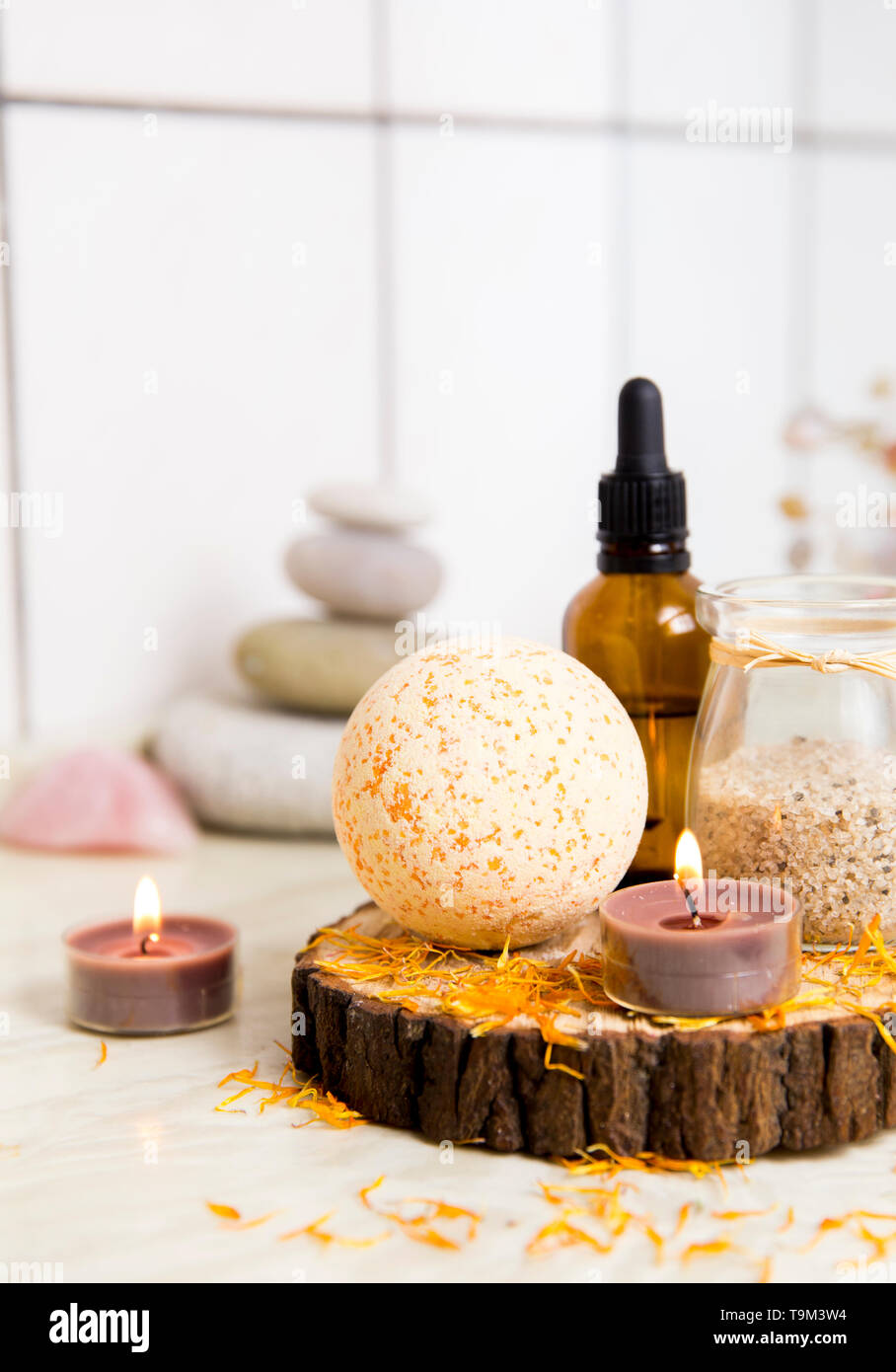Vue latérale d'accueil produits wellness spa bath bomb orange, arôme, sel de bain, éponge de mer, plateau de bougies allumées. Ensemble très zen, arbre d'amour et de l'améthyste cryst Banque D'Images