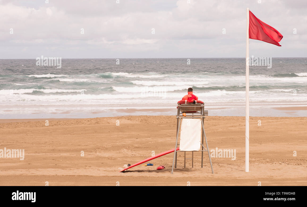 Un sauveteur assis sur la tour de surveillance, face à la mer Banque D'Images