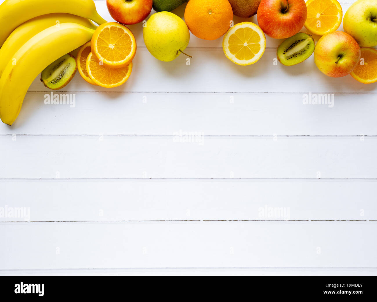 Fruits d'été frais colorés orange banane kiwi blanc apple sur fond de bois, saine alimentation épicerie biologique sur la table, la nutrition de régime vitamine detox Banque D'Images