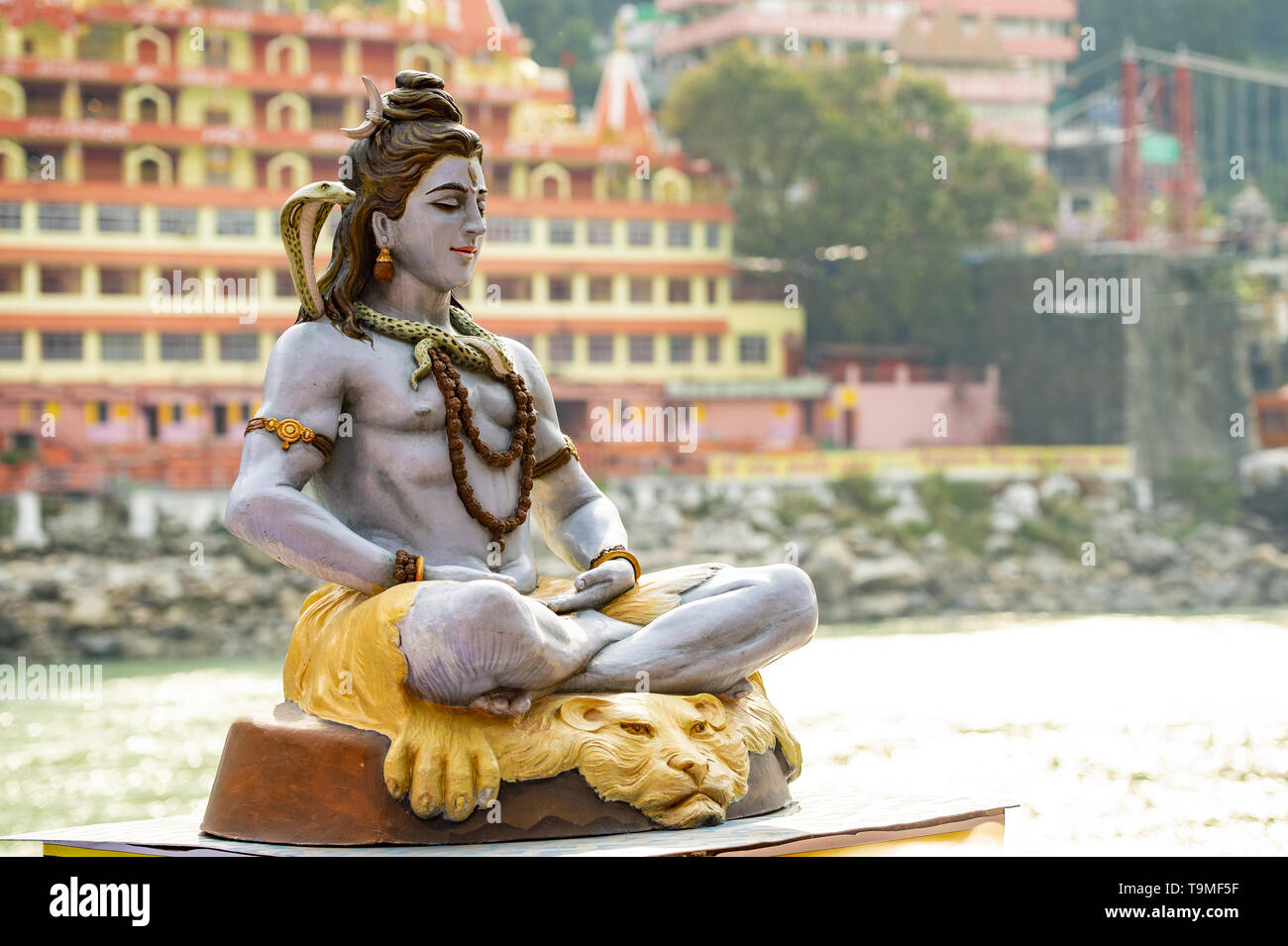 Belle vue de la statue de seigneur Shiva assis sur la rive du Gange. Blurred Trimbakeshwar Temple dans l'arrière-plan. Banque D'Images