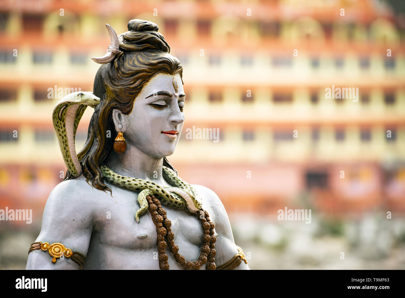 Belle vue de la statue de seigneur Shiva assis sur la rive du Gange. Blurred Trimbakeshwar Temple dans l'arrière-plan. Banque D'Images