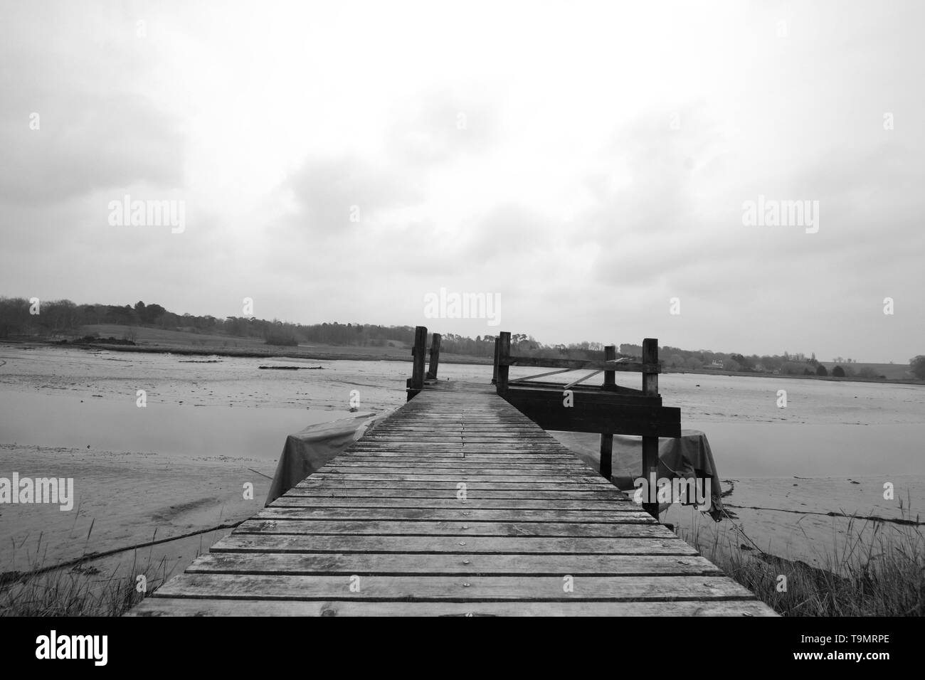 Photographie en noir et blanc d'une jetée sur la rivière Deben, Woodbridge, Suffolk, Royaume-Uni Banque D'Images