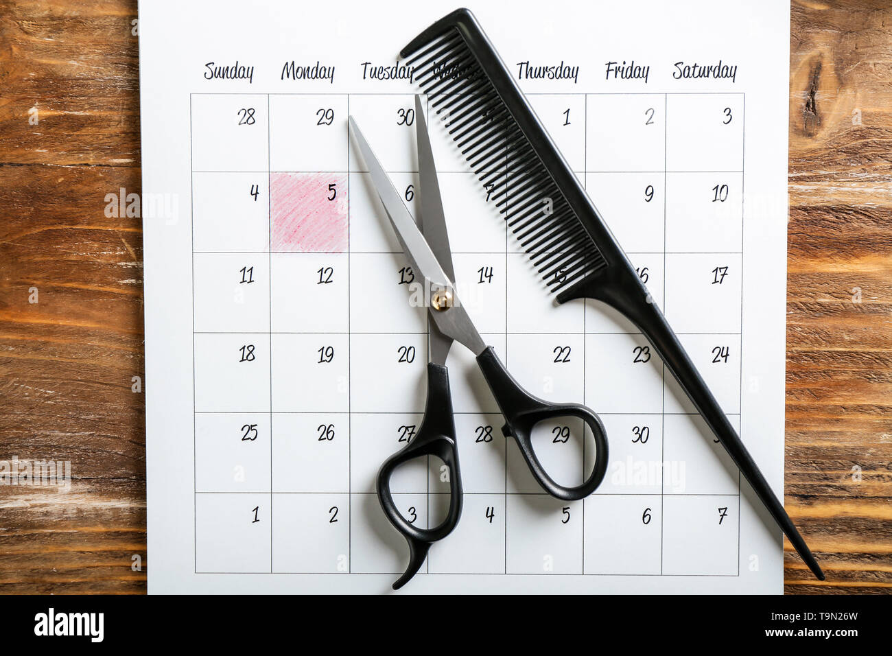 Calendrier avec des outils de coiffure sur fond de bois Banque D'Images