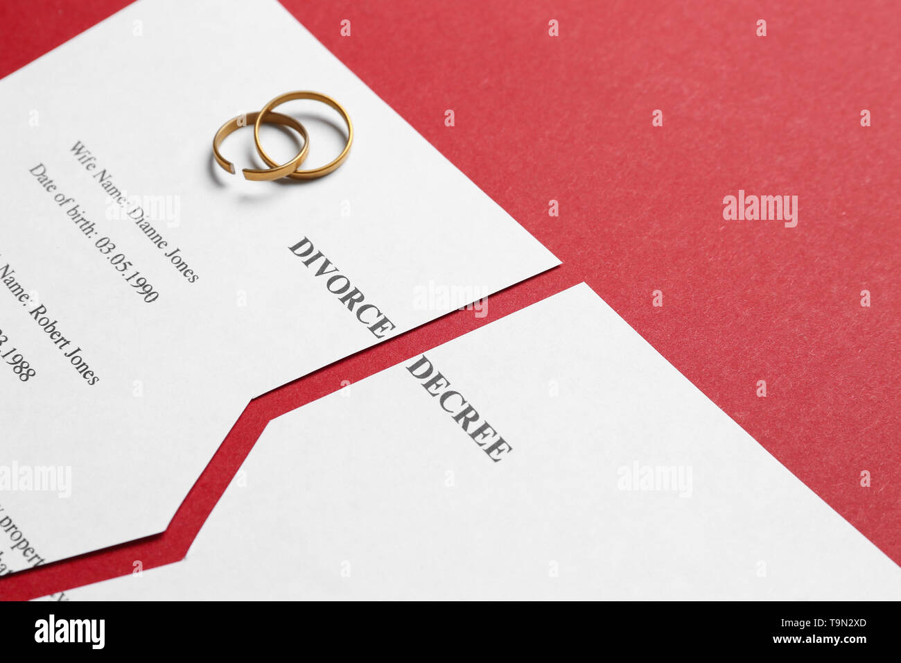 Le jugement de divorce déchiré avec des anneaux sur un fond de couleur Banque D'Images