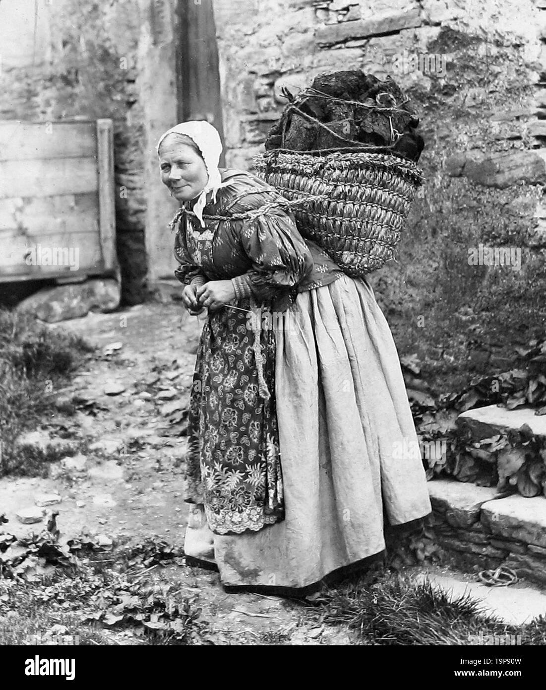 Dame transportant la tourbe et le tricot, Îles Shetland Banque D'Images