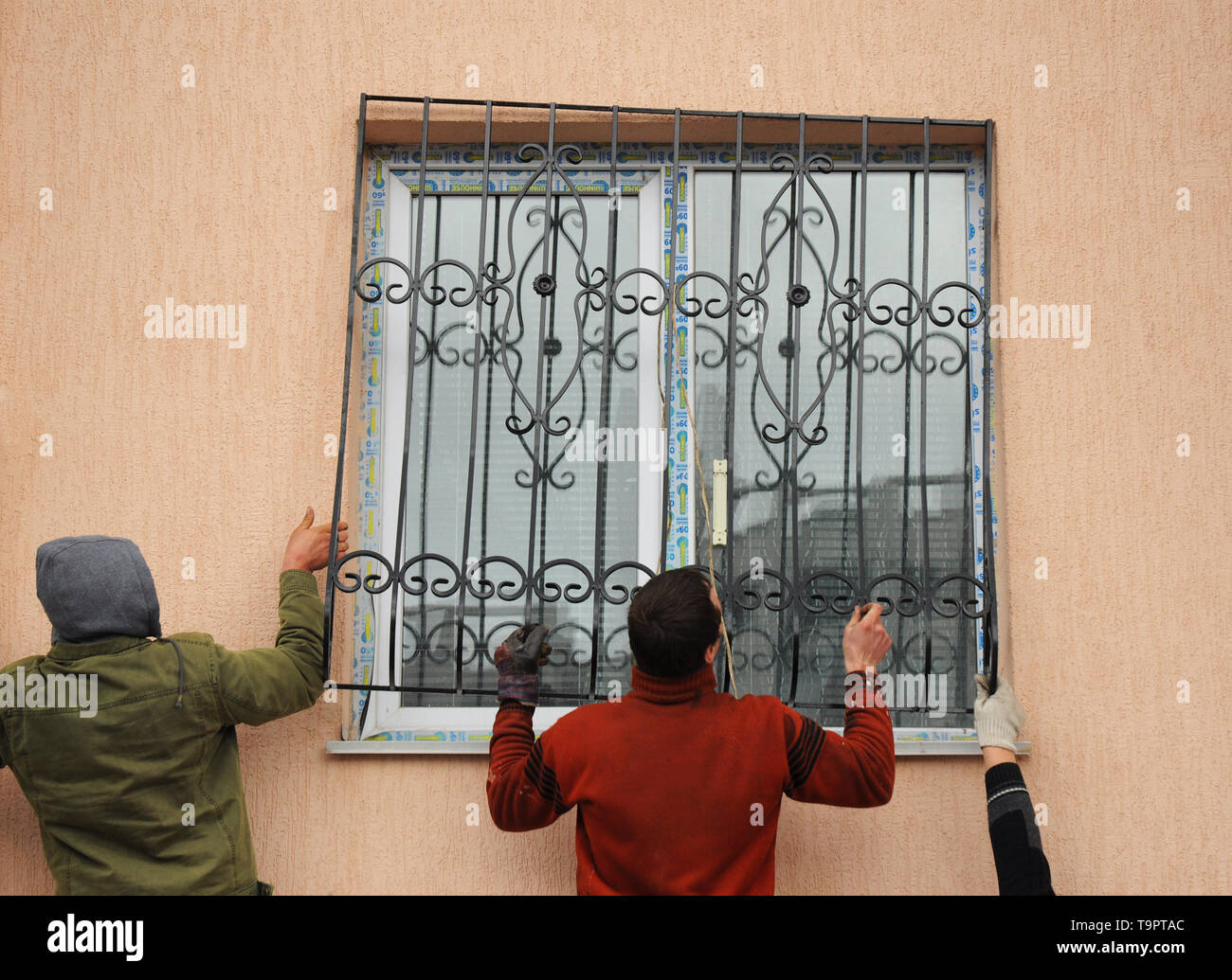 KIEV, UKRAINE - Février 5, 2016 : Gros plan sur la fenêtre d'installation de barres de sécurité en fer. Les entrepreneurs de l'installation des barres de fer sur la nouvelle fenêtre. Banque D'Images