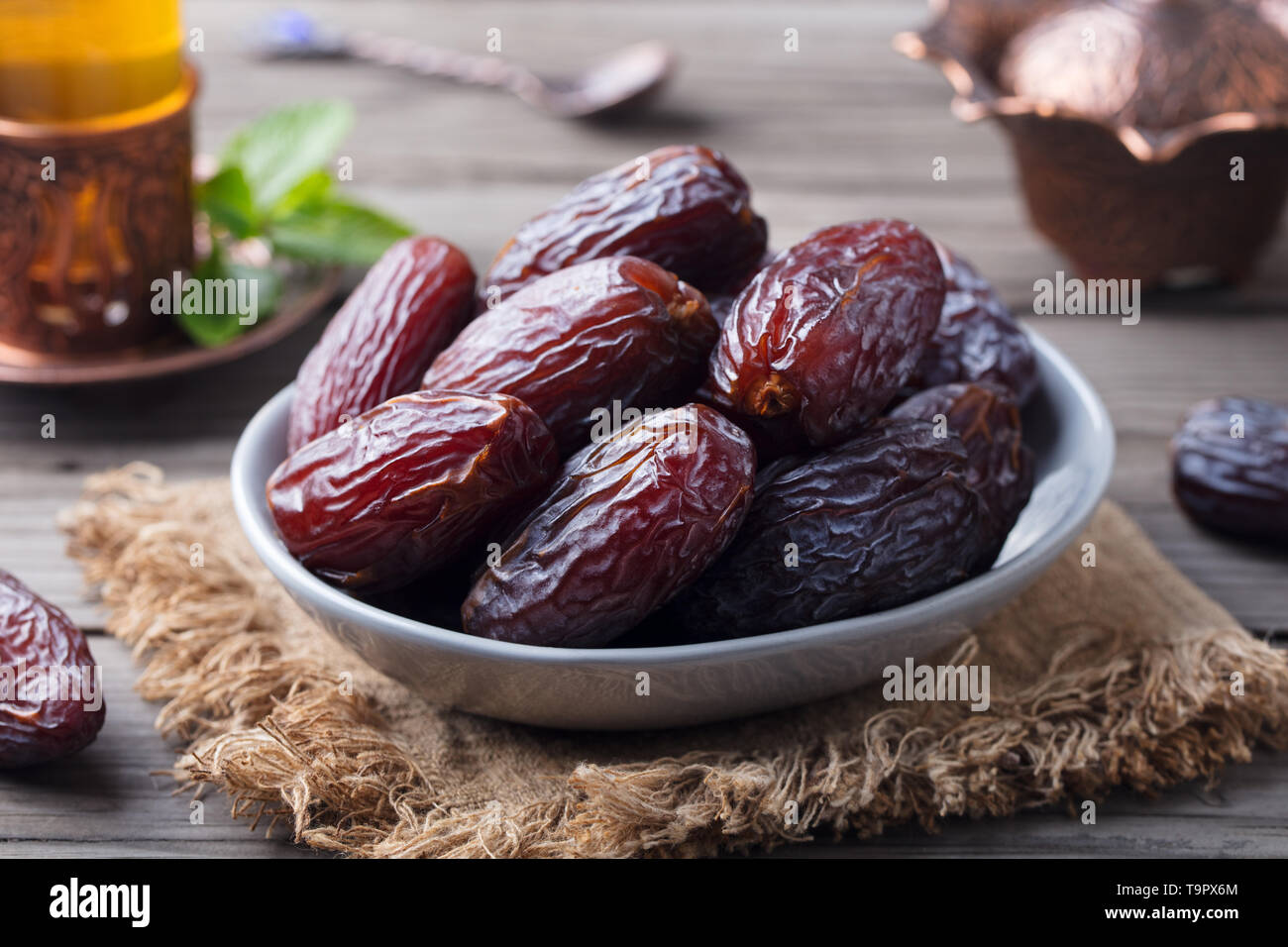 Dates fraîches Medjool dans un bol avec du thé. Ramadan kareem. Fond de bois gris. Banque D'Images