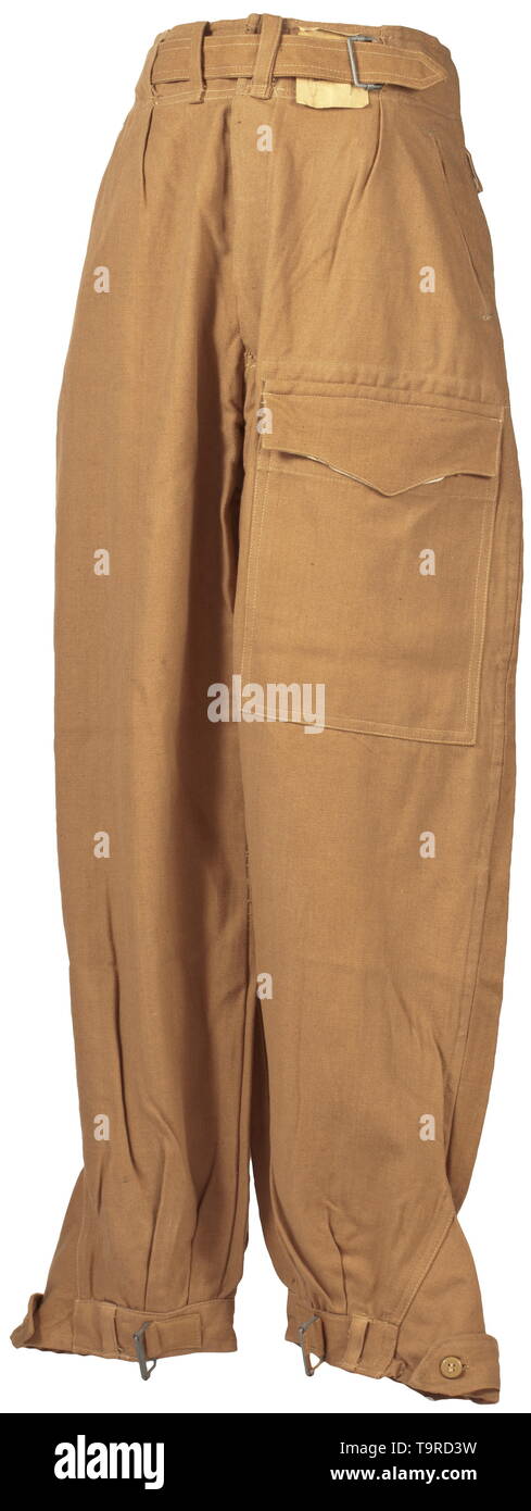 Une paire de pantalon avec poche de jambe (soi-disant "Ramcke-Hose') pour les régions tropicales de l'habillement de la Luftwaffe depot morceau avec Reich numéro d'usine la variante de la question dans de solides brown cotton twill avec boutons en résine synthétique marron. Ceinture intégrée avec fermoir coulissant, a soulevé l'arrière et boutons pour porter avec bretelles, couverts de mouche, oblique bouton poches avant, la jambe droite et poche intégrée poche arrière avec fermeture des volets. Jambe droite fermeture avec bornes de bandes. La base de la chemise en tissu, Sacs de poche de toile blanche, RB nombre et de la taille des emboutis. Color-frais, avec le papier inutilisé t, Editorial-Use-seulement Banque D'Images