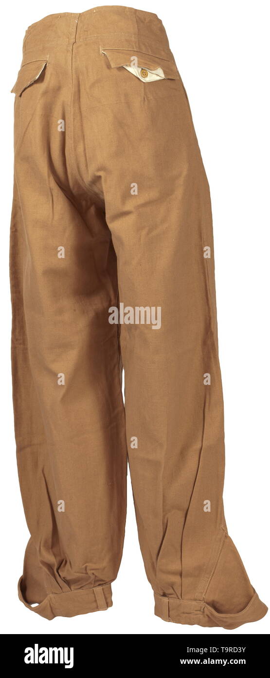 Une paire de pantalon avec poche de jambe (soi-disant "Ramcke-Hose') pour les régions tropicales de l'habillement de la Luftwaffe depot morceau avec Reich numéro d'usine la variante de la question dans de solides brown cotton twill avec boutons en résine synthétique marron. Ceinture intégrée avec fermoir coulissant, a soulevé l'arrière et boutons pour porter avec bretelles, couverts de mouche, oblique bouton poches avant, la jambe droite et poche intégrée poche arrière avec fermeture des volets. Jambe droite fermeture avec bornes de bandes. La base de la chemise en tissu, Sacs de poche de toile blanche, RB nombre et de la taille des emboutis. Color-frais, avec le papier inutilisé t, Editorial-Use-seulement Banque D'Images