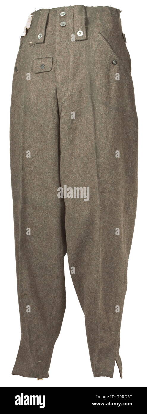 Une paire de pantalons M 43 pour le personnel de l'armée depot pièce par Timon, Vienne, avec Reich numéro d'usine champ brunâtre-gris tissu filé (grattage) de tôle et de boutons en bois sombre. Soulevé d'usure arrière avec bretelles, deux des quatre boucles de ceinture large utilisé pour fixation à bretelles, l'objet voler avec brown imitation soie renforcement, la poche avec rabat de fermeture fob, l'oblique intégrée poches devant et la poche droite avec fermeture bouton, les bornes de la jambe avec chute et de maintien. Chemise en coton blanc avec RB Nombre et taille de l'estampage. Petit ble, Editorial-Use-seulement Banque D'Images