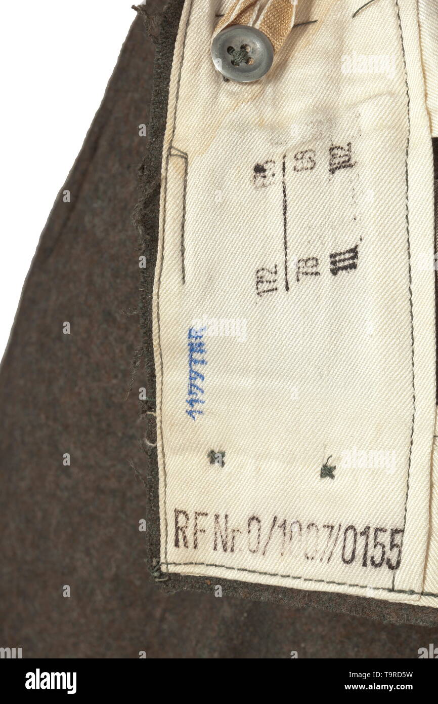 Une paire de pantalons M 43 pour le personnel de l'armée depot pièce par Timon, Vienne, avec Reich numéro d'usine champ brunâtre-gris tissu filé (grattage) de tôle et de boutons en bois sombre. Soulevé d'usure arrière avec bretelles, deux des quatre boucles de ceinture large utilisé pour fixation à bretelles, l'objet voler avec brown imitation soie renforcement, la poche avec rabat de fermeture fob, l'oblique intégrée poches devant et la poche droite avec fermeture bouton, les bornes de la jambe avec chute et de maintien. Chemise en coton blanc avec RB Nombre et taille de l'estampage. Petit ble, Editorial-Use-seulement Banque D'Images