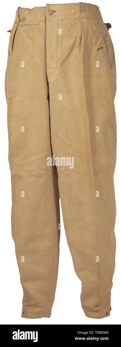 Une paire de 2ème modèle pantalon tropical pour la Waffen-SS depot morceau de velours côtelé de couleur sable avec boutons en résine synthétique. La taille, avec cinq inversé, crochets de transport ceinture peints en brun et deux sangles de marche arrière pour la fixation du porte jarretelles. Couverts fly, fob intégré poche, deux poches avant et oblique de la hanche droite poches chacun d'un bouton de fermeture en forme de coin, les bornes de la jambe avec insewn les bandes de traction. Chemise en coton blanc avec la taille de l'estampage. Historique des tâches., historique, 20e siècle, Editorial-Use-seulement Banque D'Images