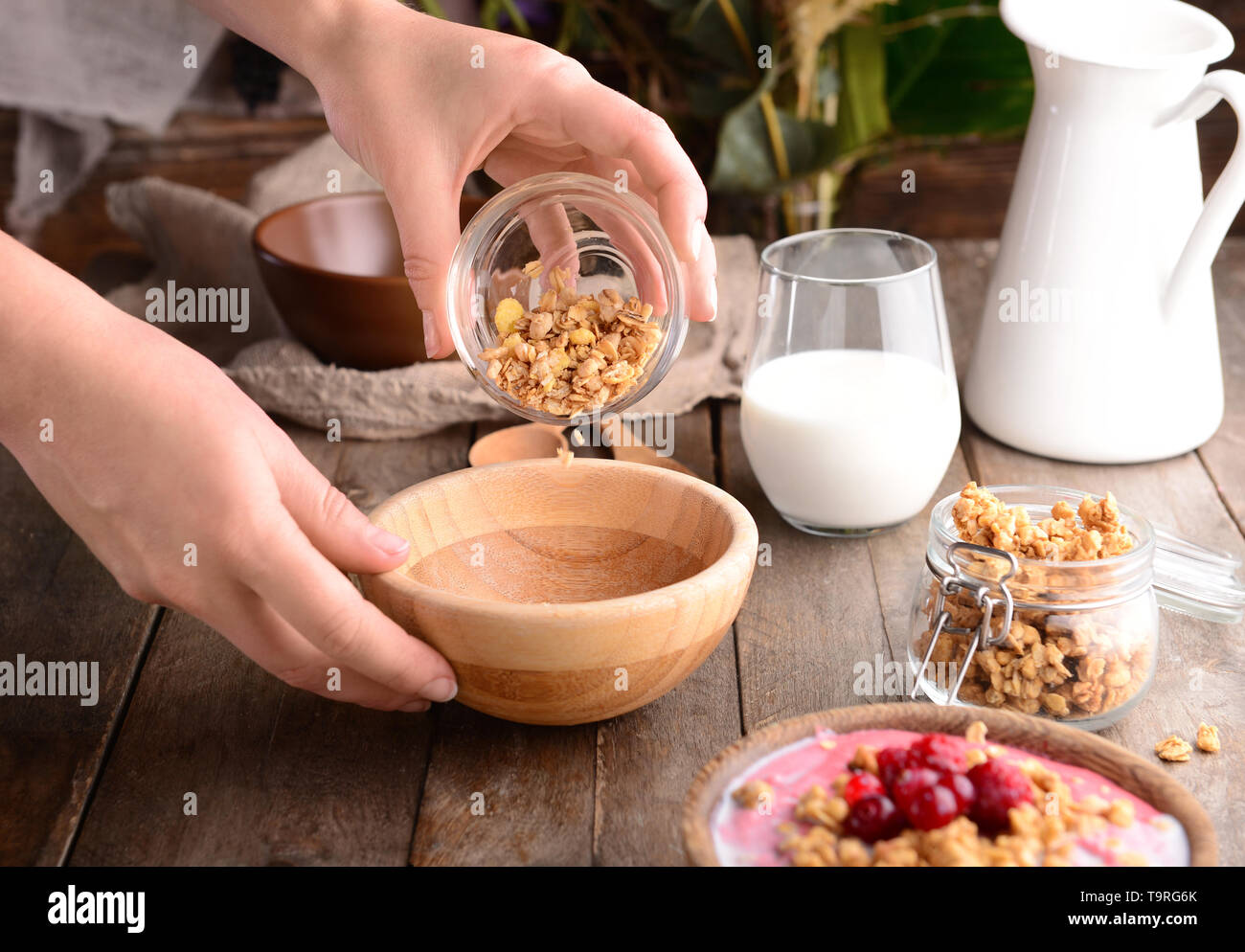 Femme préparant de délicieux muesli in kitchen Banque D'Images