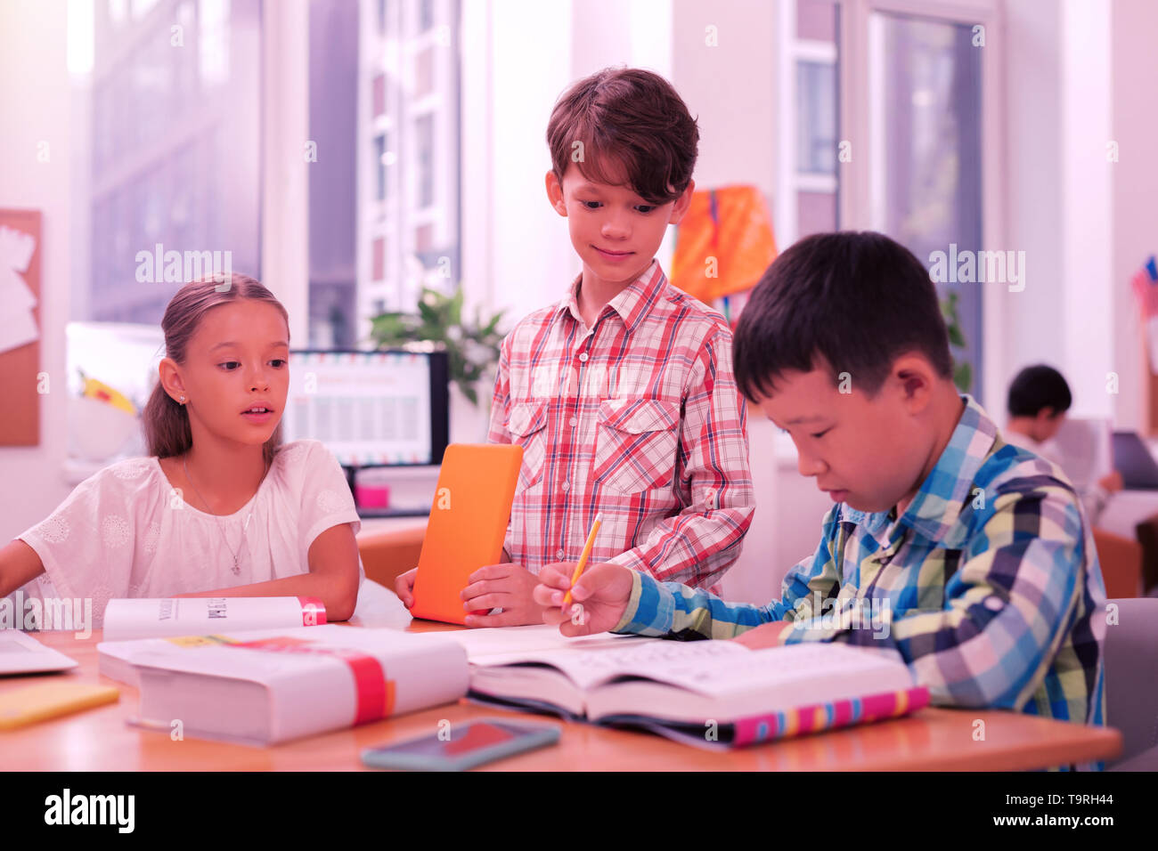 Deux garçons et une fille à la leçon. Banque D'Images