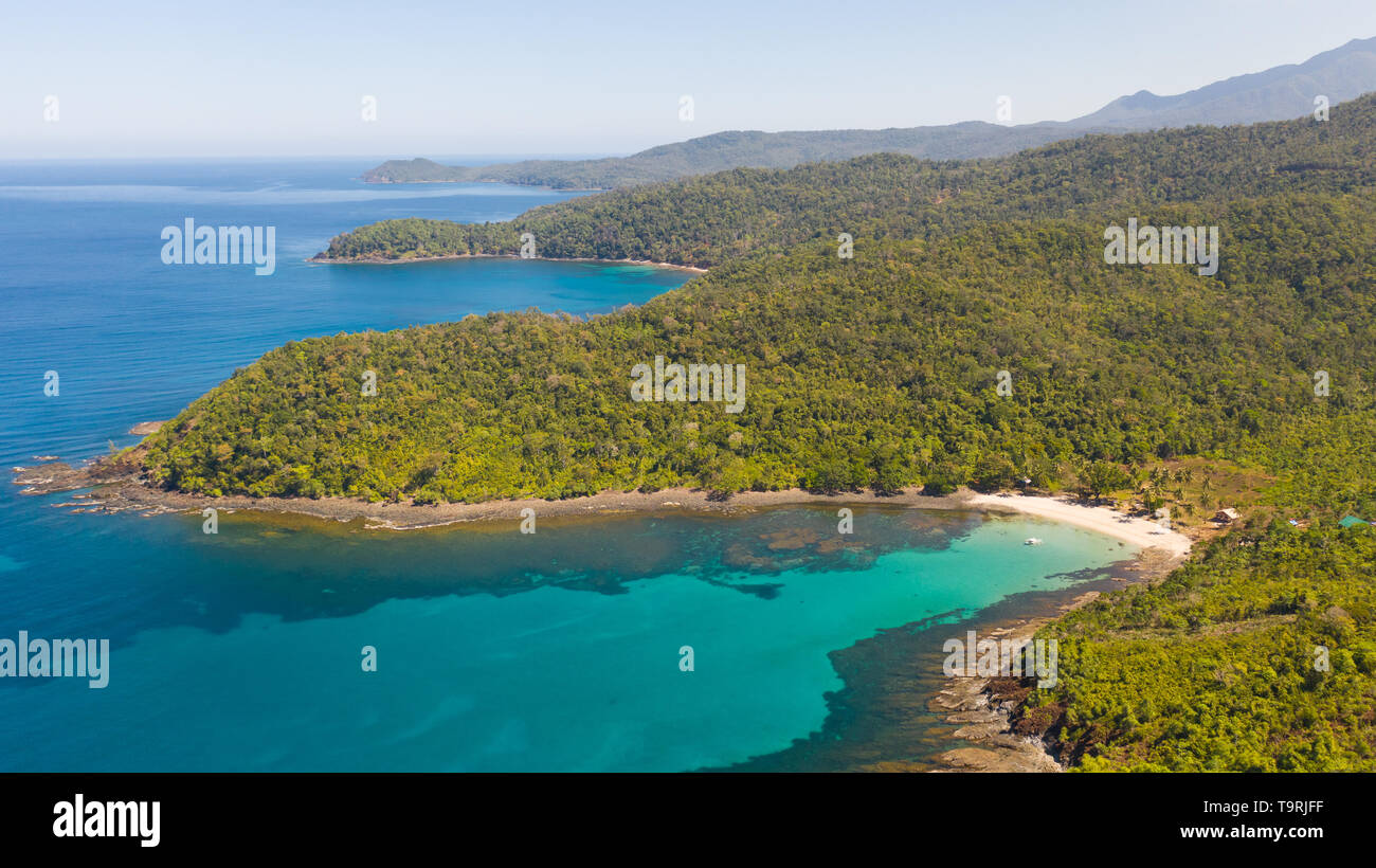 Mer baie aux eaux turquoises et d'une petite plage de sable blanc.Côte de l'île de Camiguin, Philippines.magnifique lagon et l'île volcanique couverte de forêts denses, vue de dessus. Banque D'Images