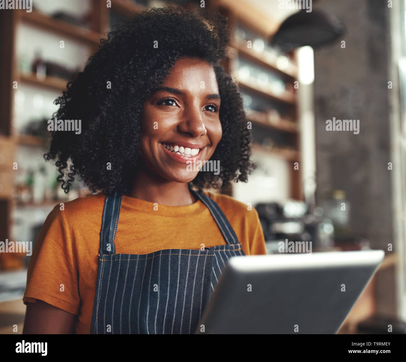 A smiling female cafe owner with digital tablet Banque D'Images