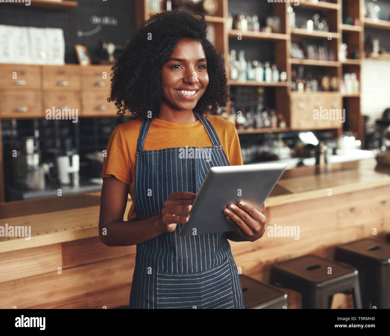 Female propriétaire à son café shop holding digital tablet Banque D'Images