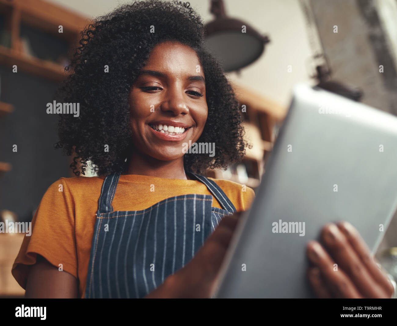 Femme debout dans barista coffee shop using digital tablet Banque D'Images