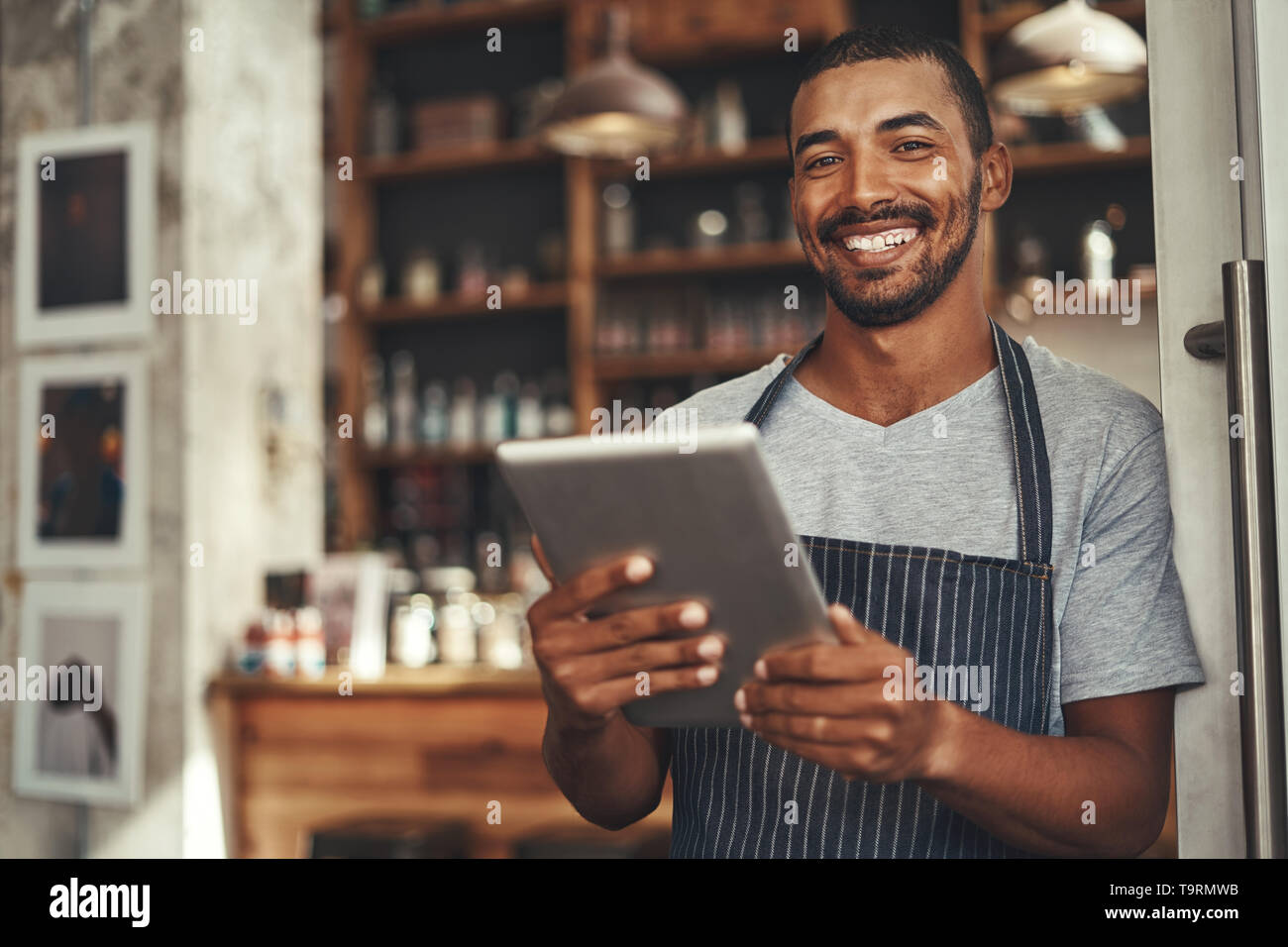 Male cafe owner holding digital tablet dans sa main Banque D'Images