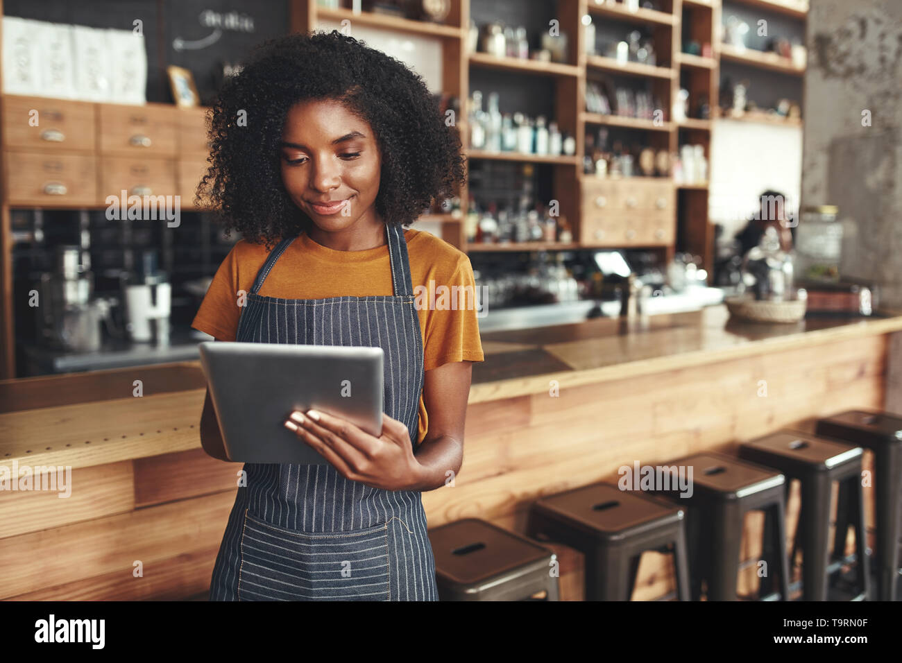 Propriétaire réussi de petite entreprise à l'aide de tablette numérique dans son café Banque D'Images