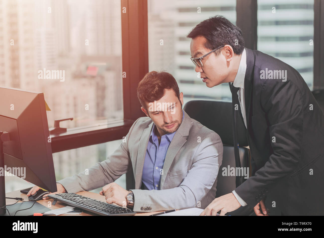 Deux business man avec mix partenaire asiatique de course et homme de race blanche, Patron de l'aide de travail exécutif avec soins en fonction de l'employé. Banque D'Images